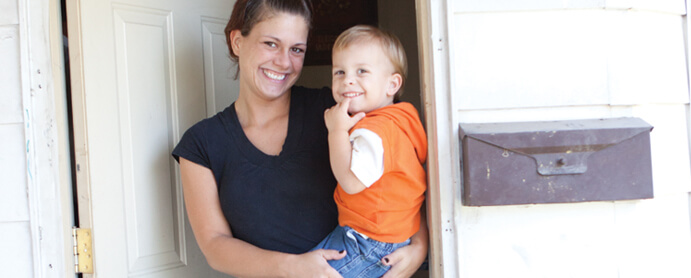 Mother holding child in doorway