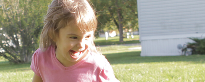 little girl playing outside in the grass